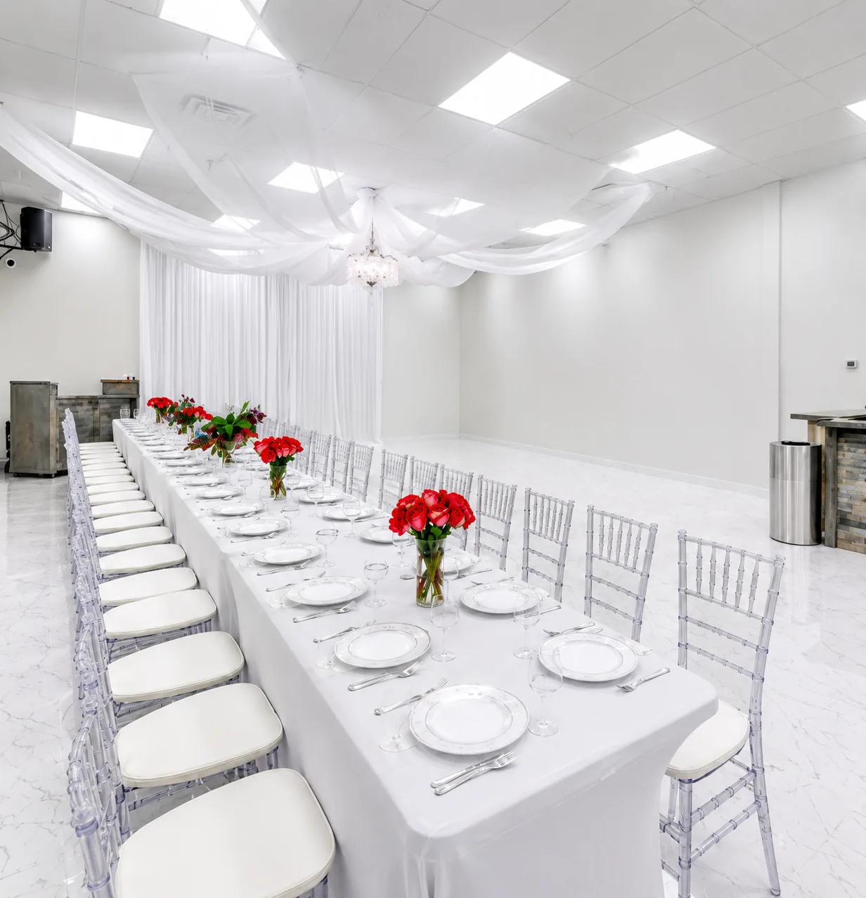 Long table with draped ceiling and red roses